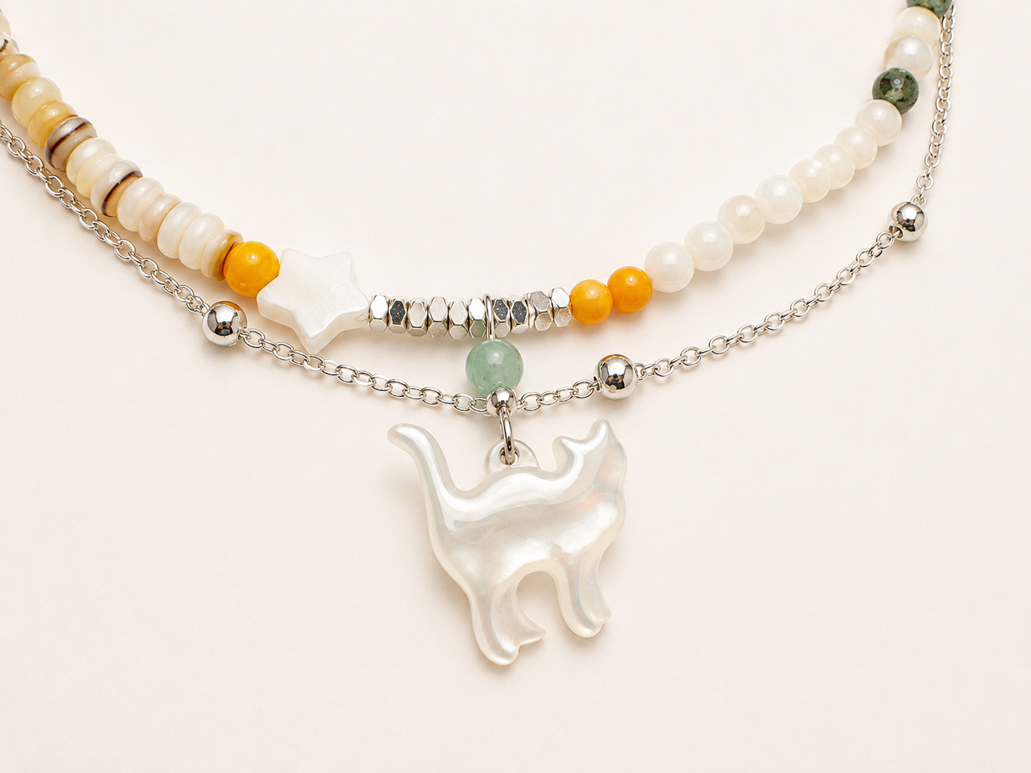 Pearl cat charm necklace featuring natural gemstone beads, layered chain and pearl pendant.